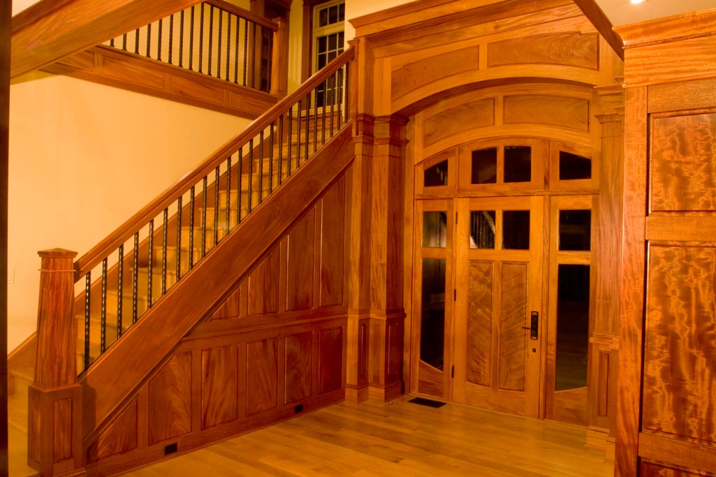 Entry foyer to Artisan House. The arched panels above the door were paneled with the grain arching in the same radius. A theme of pairs is present through this room.