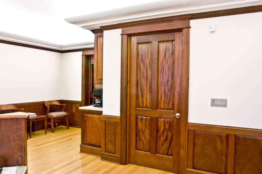 This corporate reception area is executed in solid mahogany with some of the most amazing ribbon grain panels in one of twenty custom made doors. We buy the figured wood in thick form and resaw them in our shop. The cove lighting was designed to give indirect light.