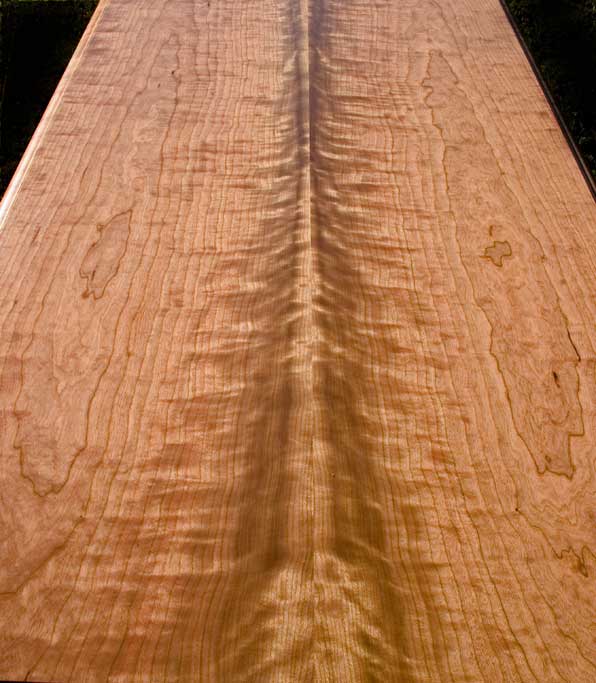 This two board cherry top appears to turn three dimensional as you walk around it. The strong symmetry brought by two bookmatched pairs is hard to beat for table or desk tops.